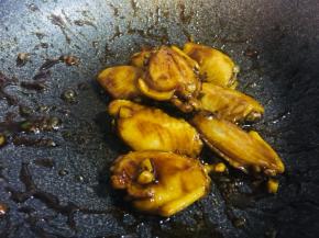 翻炒至图片状态，汤汁几乎全干，鸡翅周身颜色变深关火