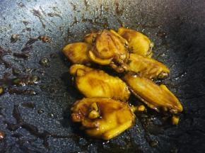 翻炒至图片状态，汤汁几乎全干，鸡翅周身颜色变深关火