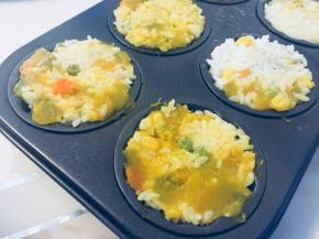 然后继续填充米饭，把馅料盖住，表面用铲子压平