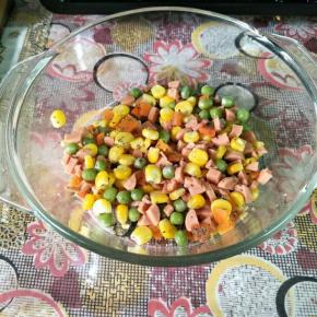 杂蔬粒放锅里煮熟捞出沥干水分，火腿肠切小丁，加入盐、黑胡椒、罗勒碎和沙拉酱拌匀