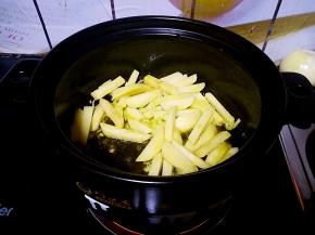 油热后放入土豆条翻炒。加入葱花和花椒粉爆香。