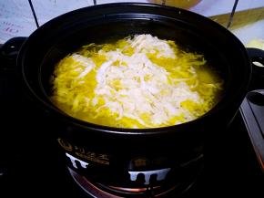 把酸菜抓散放入锅中。