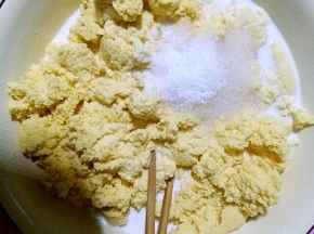 h在发酵好的玉米面中加入白砂糖一个鸡蛋还有少许的小苏打，再慢慢的加入鲜牛奶搅拌。