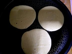 饼铛烧热刷油，用勺子把搅拌好的玉米面倒在饼铛上，任其自然摊开。