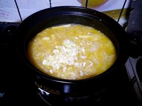 把所有的玉米饼烙好之后，砂锅中的菜也熟了。加入一些葱花和少量的味精搅拌一下。