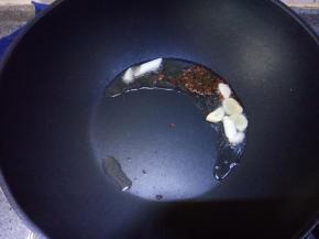 座锅放入2勺色拉油，放入蒜、葱、姜和花椒、麻椒炸制，至蒜、葱、姜炸成金黄偏糊的状态