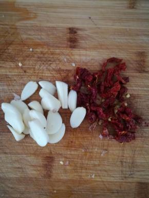 大蒜去皮，切片。干辣椒切段。