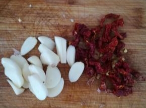 大蒜去皮，切片。干辣椒切段。