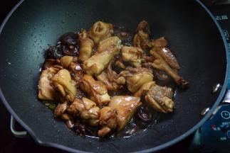 然后加入香菇，调入料酒、白砂糖、酱油、老抽和蚝油炒匀上色