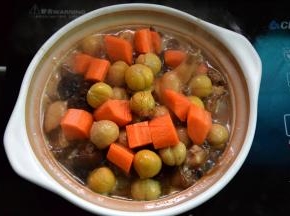 把鸡肉转入砂锅，加入栗子和胡萝卜拌匀再倒入泡香菇的水小火煲30分钟
