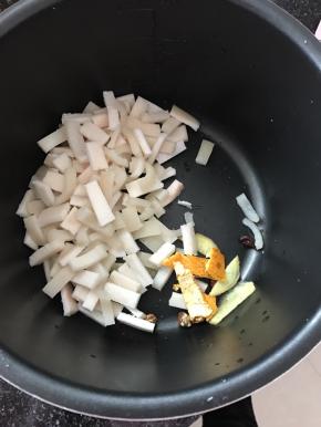 将猪皮多余的油脂剃干净，切成小丁，放入锅中