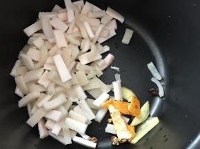 将猪皮多余的油脂剃干净，切成小丁，放入锅中
