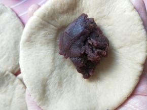 用擀面杖擀薄，包入豆沙