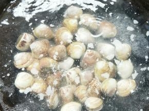 将洗干净的蛤蜊放入锅中焯至外壳张开