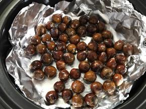 把沾上油的板栗均匀地铺在砂锅里面。