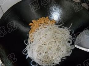 肉末拨一边，倒入泡好的粉丝，炒匀。