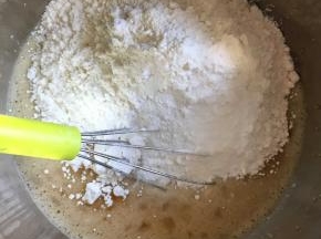 j加入过筛的泡打粉和低粉，轻轻敲打，将面粉与蛋黄糊混匀，不要太过用力，起筋了就不好了。