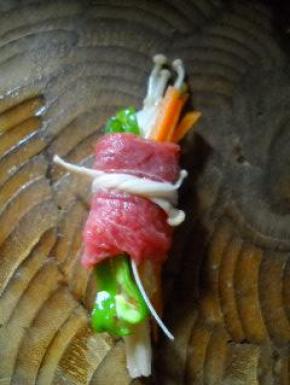 用一根长的金针菇将牛肉卷系好。