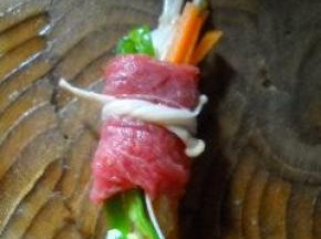 用一根长的金针菇将牛肉卷系好。