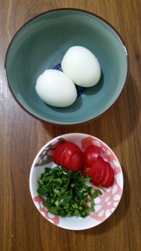 2、煮熟的鸡蛋去壳，番茄切片，香菜洗净切碎。