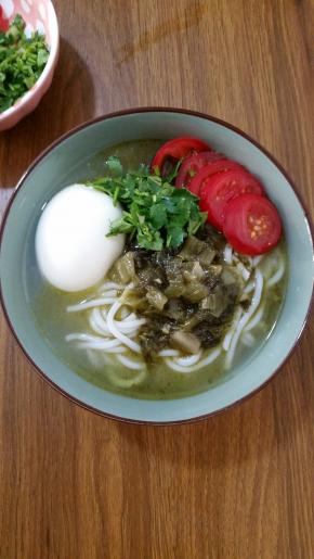 7、将酸菜牛肉原汤倒在米粉上，摆上小番茄片，再撒一把香菜碎，还有大块的牛肉哦。