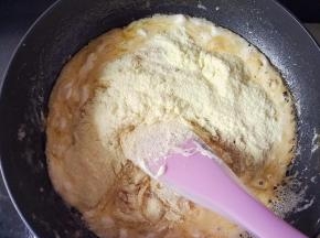 再把奶粉倒入融化好的棉花糖里，均匀搅拌下