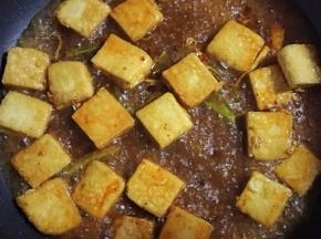 把豆干和香料水倒入平底锅里