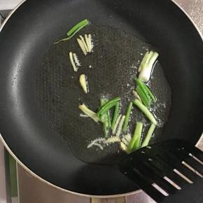 平底锅洗净后加入少许葱段，姜丝爆香