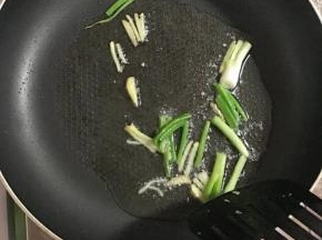 平底锅洗净后加入少许葱段，姜丝爆香