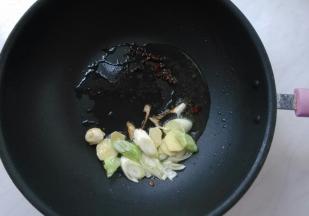 起锅热油，放入花椒粒，爆香，推至锅边。下葱花、姜片。