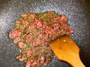 5.油热后加入腌制好的牛肉糜炒制，待炒到变色后，盛出