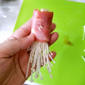 包入适量金针菇卷起，用牙签固定住