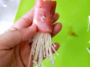 包入适量金针菇卷起，用牙签固定住