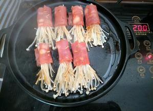 放入培根卷小火慢煎，金针菇上再刷少许酱汁，中途要翻面煎熟