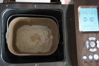 倒入面粉，在面粉顶端加入酵母，将面包桶放入到东菱1352-AE面包机里，启动面包机的和面程序10分钟