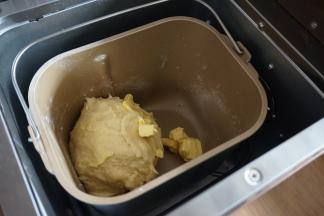 在第一次和面结束后，静置5-8分钟，再放入软化的黄油块，继续启动面包机的和面程序18分钟