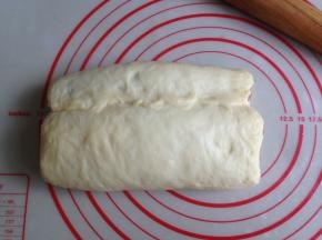 将白色面团的上部向下盖住可可面团，捏紧收口