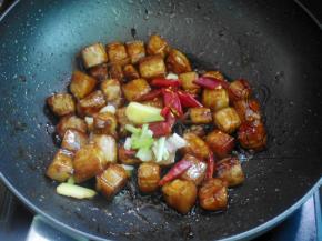 加入冰糖炒融化然后加入红烧酱油将五花肉炒匀上色，再加入萄姜蒜八角干辣椒