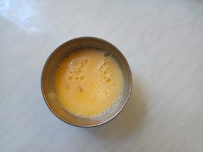 鸡蛋打散，沿一个方向轻轻搅拌蛋液和水。避免力度太大，泡沫就越多，蒸出来蜂窝就多。