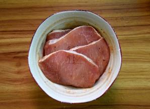 猪排两面用盐和胡椒粉撒上，加烧烤酱拌匀腌制一会