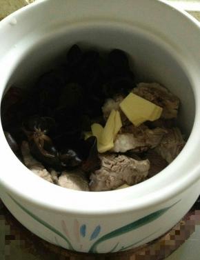 加入泡发好的黑木耳，切成片的生姜，倒入料酒，加盐