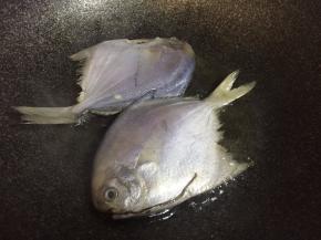 洗净且收拾干净的鲳鱼放入油锅中煎至表面金黄，取出沥油