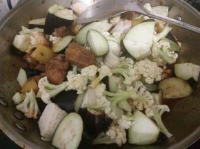 土豆烂了再加入冻豆腐、花菜、茄子，炒匀后继续炖至蔬菜熟了。