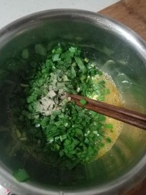 把韭菜末倒入蛋液中，再撒少许白胡椒粉