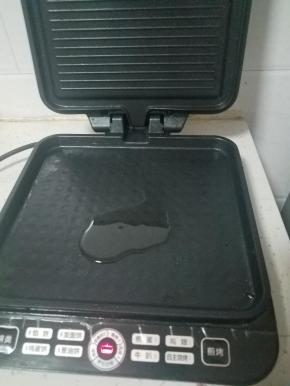 电饼铛开下键，淋少许油预热