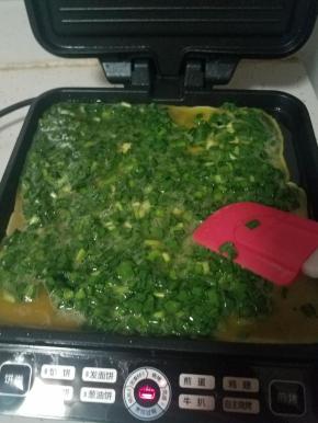 预热完成后，倒入蛋液，用刮刀刮干净后，轻轻的把电饼铛的蛋液铺平