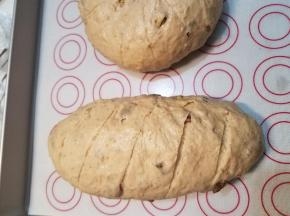 取出烤盘，烤箱上下火170度预热，去掉保鲜膜，在面包坯上筛一层薄薄的干面粉，用面包整形刀造型。