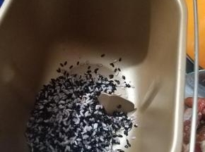 泡好的米沥水后放入到面包机桶内。