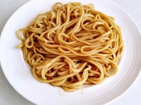 捞出面条放入盘中。