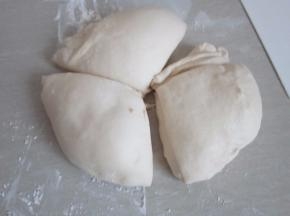 将发好的面团轻拍排气分割成三等份。